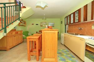 a kitchen with wooden cabinets and a staircase at Stone House Oreb`s Cottage in Vela Luka