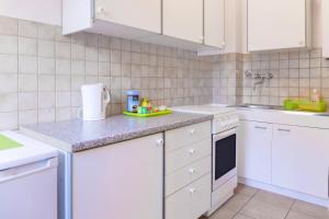 cocina con armarios blancos y encimera en Ferienwohnung Wideystrasse en Witten