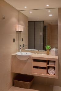 a bathroom with a sink and a large mirror at Hotel COZZI Zhongxiao Taipei in Taipei
