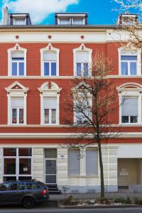 ein rotes Backsteingebäude mit einem davor geparkt in der Unterkunft Apartment Wideystrasse in Witten
