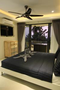 a bedroom with a bed with a ceiling fan at Baan Seaview Holiday Villas in Lamai