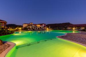 a swimming pool with a pool table and chairs at Hotel Sa Cheya Relais & Spa in Alghero