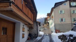 un callejón con edificios y nieve en el suelo en Casa Di Girolamo, en Predazzo