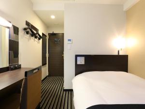 東京にあるアパホテル〈小伝馬町駅前〉のベッドとテレビが備わるホテルルームです。