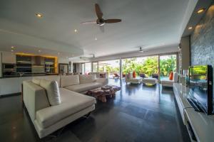 Una sala de estar con un sofá y un televisor. en Amertha Villa Dreamland, en Uluwatu