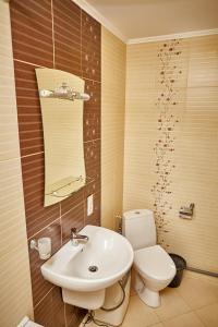 a bathroom with a white toilet and a sink at Sweet Home on Shevchenko street in Vinnytsya