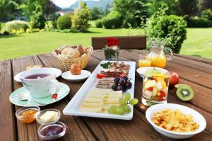 a table with a plate of food and a cup of coffee at Hotel Marko in Sankt Kanzian