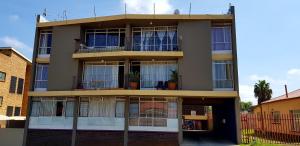 ein hohes Gebäude mit vielen Fenstern in der Unterkunft Hyswan Self Catering Guesthouse in Krugersdorp