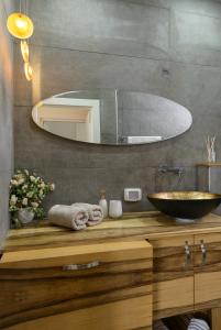 La salle de bains est pourvue d'un lavabo et d'un grand miroir. dans l'établissement Sunset TLV Apartment - Ben Yehuda 175, à Tel Aviv
