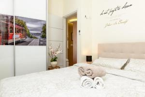 - une chambre avec un lit blanc et des serviettes dans l'établissement Sunset TLV Apartment - Ben Yehuda 175, à Tel Aviv