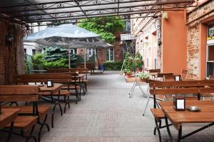 a patio with wooden tables and benches and an umbrella at Smartflat & New apartment city center in Kaunas