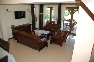 a living room with leather chairs and a table at Ostoja Spychowo in Spychowo