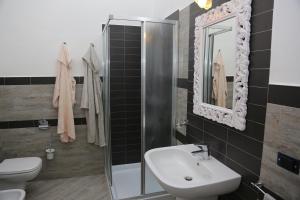 a bathroom with a sink and a toilet and a mirror at Residenze Gli Ulivi in Orosei