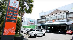 a parking lot with cars parked in front of a building at Tjokro Hotel Klaten in Klaten