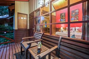 a porch with a wooden bench and a bedroom at Pinnacle Samui Resort in Mae Nam