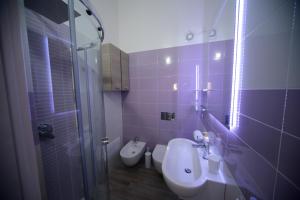 e bagno con servizi igienici, lavandino e doccia. di Suite delle Rondini Apartment ad Alghero