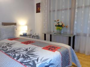 Un dormitorio con una cama con un jarrón de flores. en Zoya Apartment, en Burgas