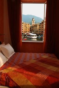 Ce lit se trouve dans un dortoir doté d'une grande fenêtre. dans l'établissement I Tre Merli Locanda, à Camogli