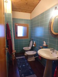 a bathroom with two toilets and a sink and a mirror at Punta Secca in Punta Secca