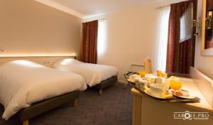 Zimmer mit 2 Betten und einem Tablett mit Essen in der Unterkunft Hôtel-Restaurant de La Paix in Saint-Palais