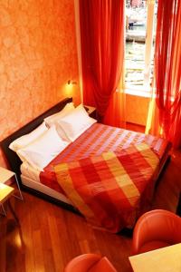 1 dormitorio con 1 cama con cortinas rojas y ventana en I Tre Merli Locanda, en Camogli