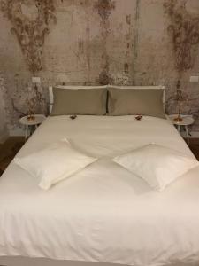 トリノにあるRapanus Suitesの白いベッド(白いシーツ、テーブル2台付)