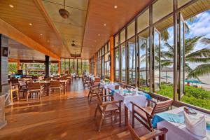 a restaurant with tables and chairs and windows at Pinnacle Samui Resort in Mae Nam