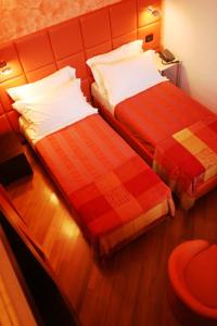 a hotel room with two beds with red sheets at I Tre Merli Locanda in Camogli