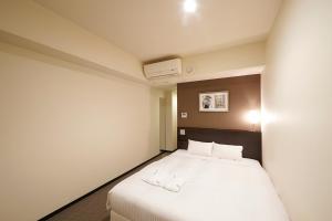 Postel nebo postele na pokoji v ubytování Sotetsu Fresa Inn Yokohama Sakuragi-cho