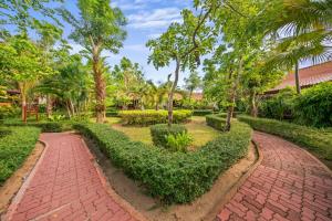 a brick path in a park with trees and bushes at Pinnacle Samui Resort in Mae Nam