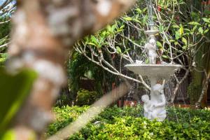 a fountain in a garden with two chericans on it at Pinnacle Samui Resort in Mae Nam