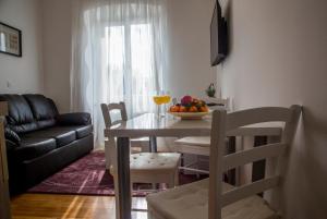 Apartments Victoria في دوبروفنيك: غرفة معيشة مع طاولة مع وعاء من الفواكه