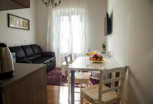 Apartments Victoria في دوبروفنيك: غرفة معيشة مع طاولة مع وعاء من الفواكه عليها