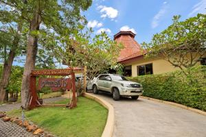 a car parked in front of a house at Pinnacle Samui Resort in Mae Nam