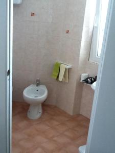 a bathroom with a white toilet and a sink at b&b le cote in Giglio Porto