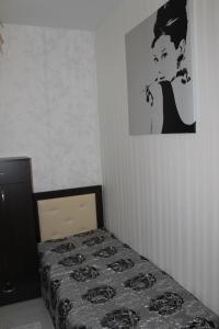 ニジニ・ノヴゴロドにあるApartament on the street Korolenkoのベッドルーム1室(ベッド1台付)が備わります。壁に絵が飾られています。
