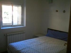 セルセディリャにあるcasa angelesのベッドルーム(ベッド1台、窓付)