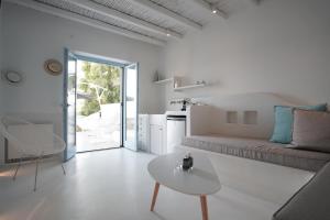ein weißes Wohnzimmer mit einer Couch und einem Tisch in der Unterkunft Pyrthea Houses in Koufonisia
