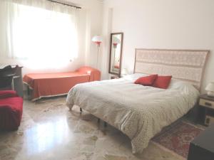 パレルモにあるAppartamento Libertàのベッドルーム1室(赤い枕のベッド1台付)