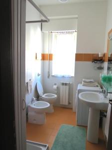 パレルモにあるAppartamento Libertàのバスルーム(洗面台2台、トイレ付)、窓が備わります。