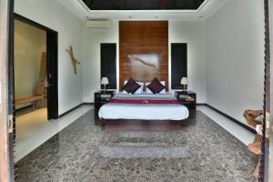 a bedroom with a king sized bed in a room at Katala Suites and Villas in Sanur