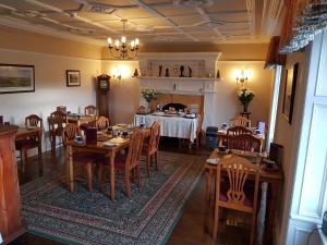a dining room with tables and chairs and a fireplace at Seaview Wellness Retreat and Guesthouse in Carnoustie