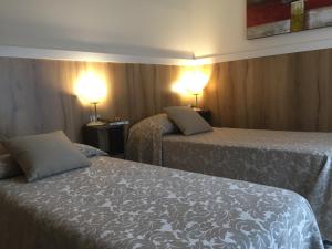 una camera d'albergo con due letti e due lampade di Poloni Apartment a Verona