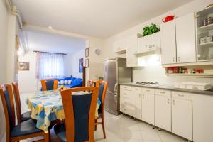 cocina y comedor con mesa y sillas en Apartments Adrijana 736, en Štinjan