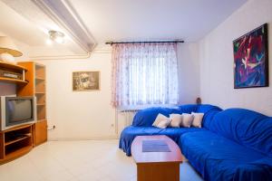 sala de estar con sofá azul y TV en Apartments Adrijana 736, en Štinjan