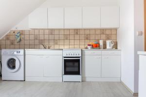 uma cozinha com armários brancos e uma máquina de lavar e secar roupa em Apartment Breite Str. 83 em Witten