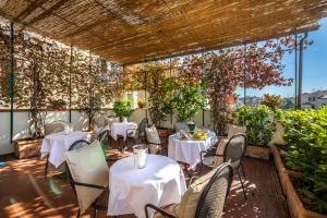 ein Restaurant mit weißen Tischen und Stühlen und Pflanzen in der Unterkunft Hotel Emma Small Luxury Hotel in Florenz