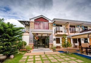 a house with a courtyard in front of it at Greenfields Tourist Inn in Panglao