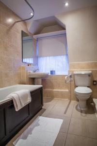 Old Swan Hotel في هاروغايت: حمام مع حوض ومرحاض ومغسلة