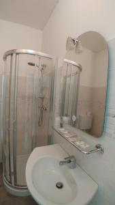 a bathroom with a sink and a shower and a mirror at Hotel Marta in Forlì